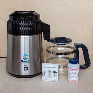 Megahome Water Distiller in Black with Brushed Steel together with Glass Carafe shown with included carbon packets and residue cleaner